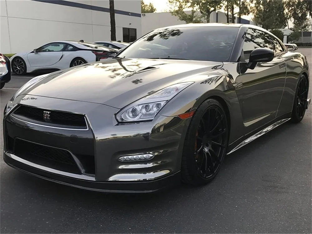 A silver Nissan GT-R sports car with a glossy chrome mirror wrap vinyl film parked outdoors.