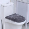 A white toilet with a gray flannel seat cover placed on the seat.