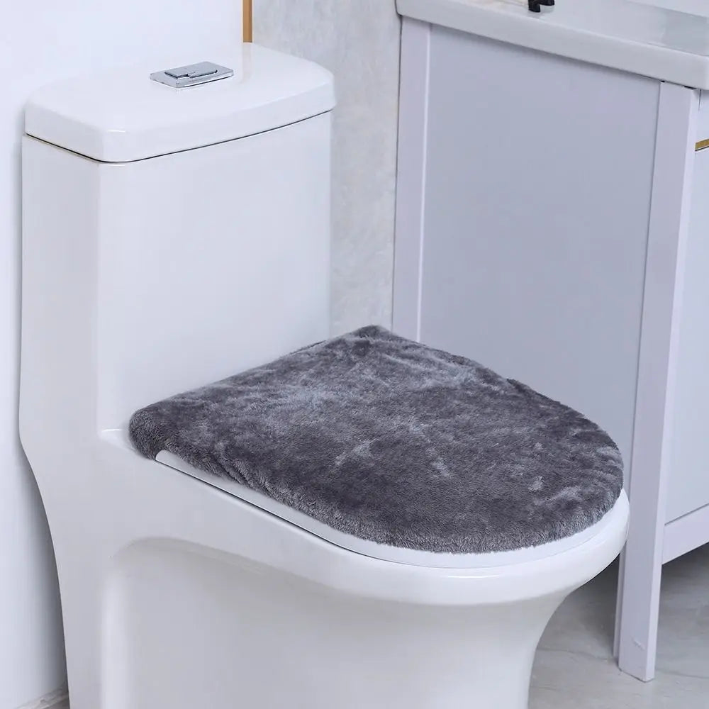 A white toilet with a gray flannel seat cover placed on the seat.