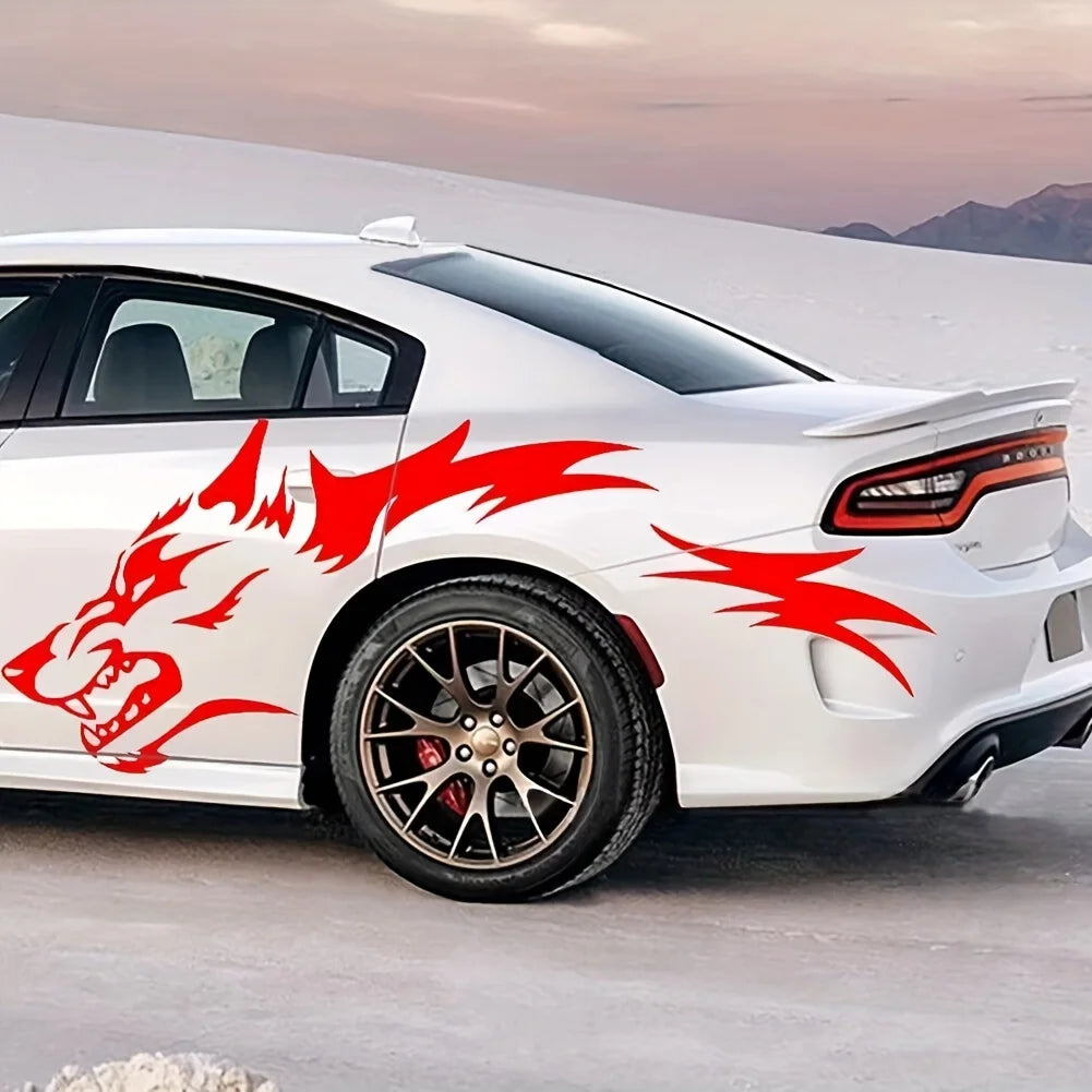 A white sports car features red flame decals on the rear fender and side, parked outdoors.