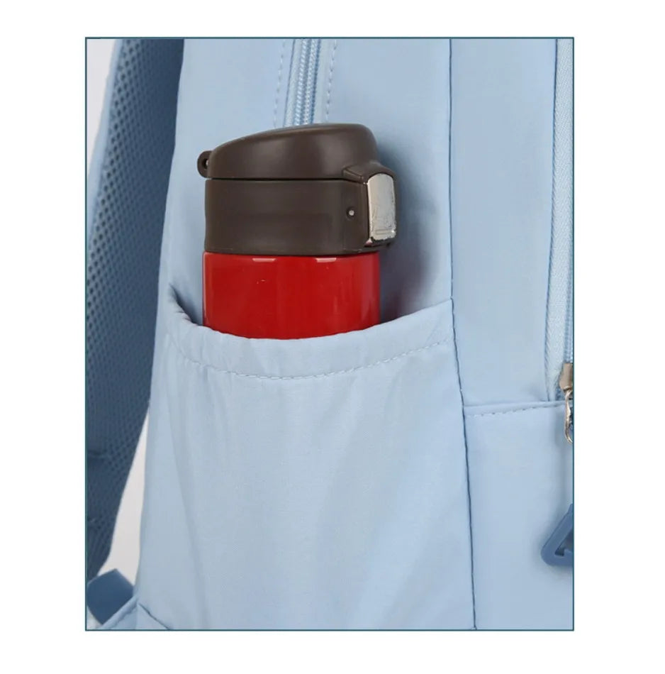 A close-up of a red and brown cylindrical item stored in a pocket of a light blue nylon backpack.
