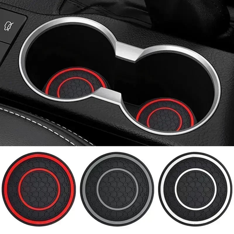 Two black silicone coasters with red accents shown in a car cup holder