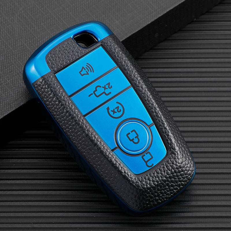 A blue TPU leather car key cover with multiple buttons rests on a dark surface.