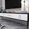 A modern kitchen counter with a black top and white drawers, set against a subway tile backsplash.