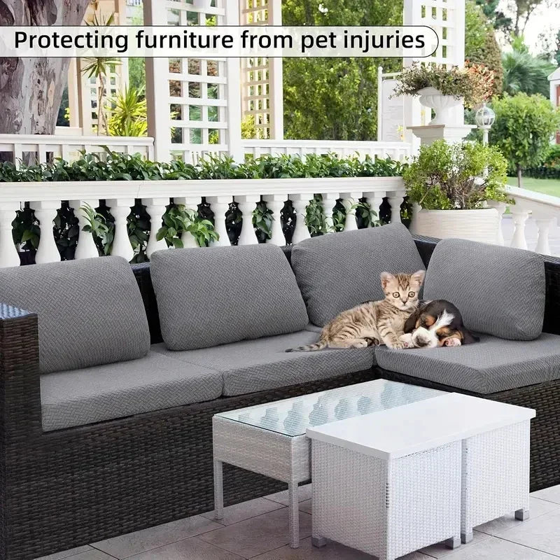 Graue L-förmige Outdoor-Sofaschiene mit einer Katze darauf, vor einem weißen Geländer.