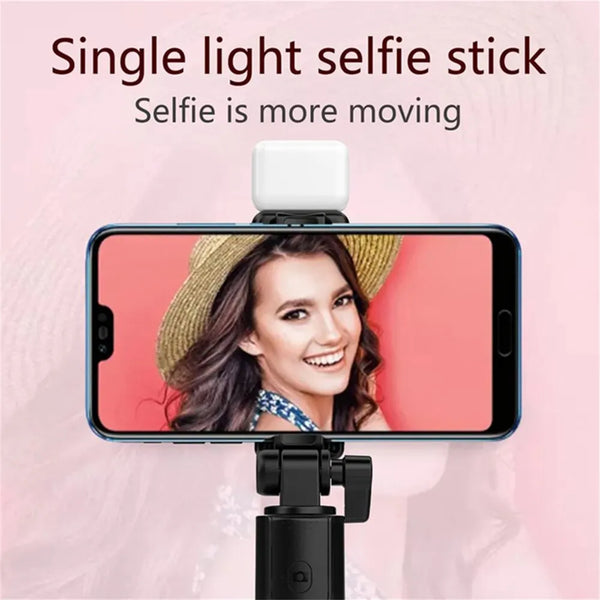 A smartphone is mounted on a selfie stick with a light, showing a woman smiling.