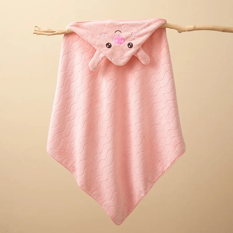 Pink quilted hooded baby bathrobe towel with a cute cartoon animal design hanging on a wooden branch