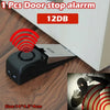 A black wireless door stop alarm device with a red signal emanating from it, shown next to a close-up of a hand with a simila