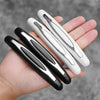 A hand holds four black and white car door edge protector strips.