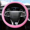 A pink silicone steering wheel cover is shown inside a car, featuring an airbag and controls.
