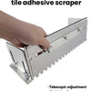 A hand is using a multi functional ceramic tile adhesive scraper with a telescopic adjustment feature on gray ceramic tiles.