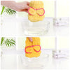 A hand is holding a yellow microfibre quick-dry hair towel wrap with a pink bowknot above a glass bowl.
