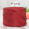 A spool of deep red metallic flat ribbon yarn for crochet and knitting.
