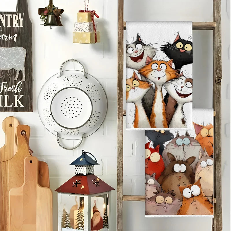 A set of two cartoon cat kitchen towels featuring orange and gray cats in various expressions.