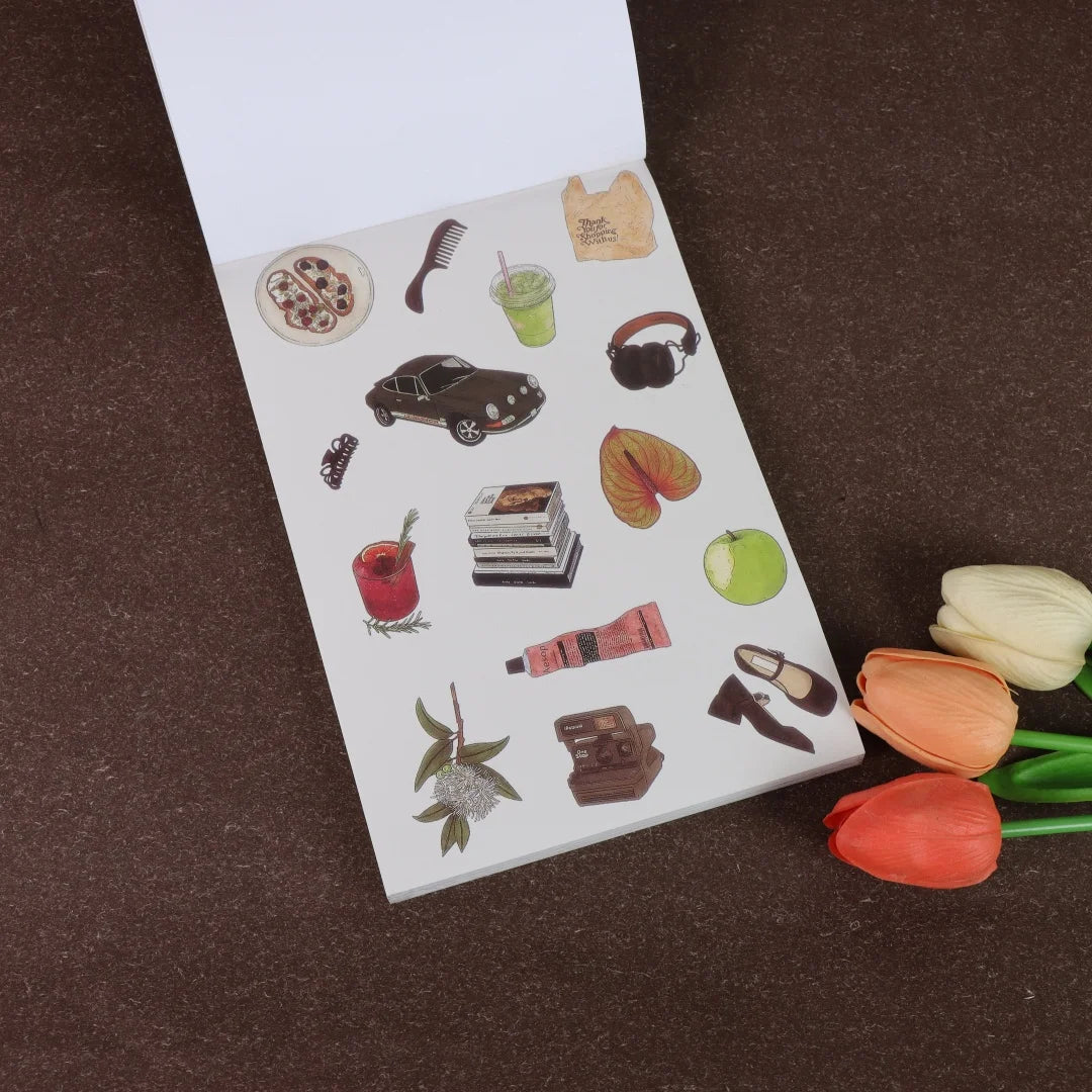 A white sticker book featuring various fruit, shoe, and accessory illustrations on a brown background.