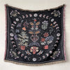 A dark black bohemian jacquard woven throw blanket featuring floral and crescent moon patterns.