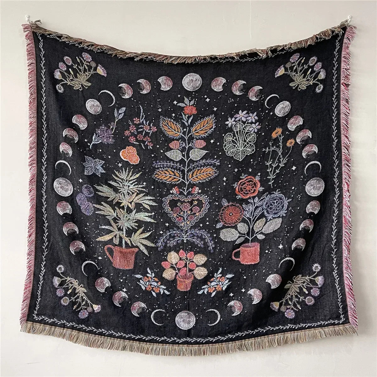 A dark black bohemian jacquard woven throw blanket featuring floral and crescent moon patterns.
