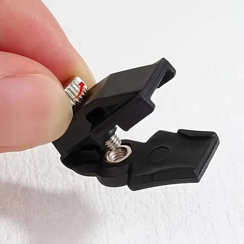 Une main tient un tire-zip noir détaché, montrant la pièce métallique argentée.