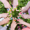 Hands of children forming a circle with colorful eye finger puppet rings for a party favor set
