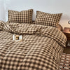 A plaid duvet cover in brown and beige tones with a checkered pattern, featuring decorative pillows.