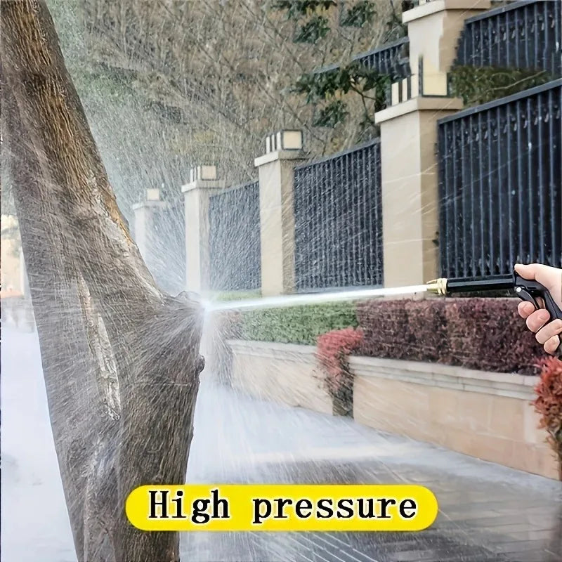 A hand is using a high-pressure water gun to spray water onto a tree trunk.