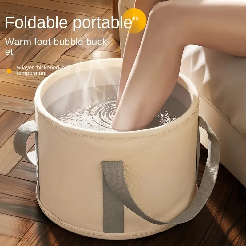 A person is soaking their feet in a portable, foldable insulated foot soak tub made of light beige material.