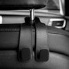 Close-up of black car headrest hooks designed for securing bags and shopping organizers.