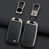 A pair of metallic key case covers with attached split rings and black rectangular key inserts.