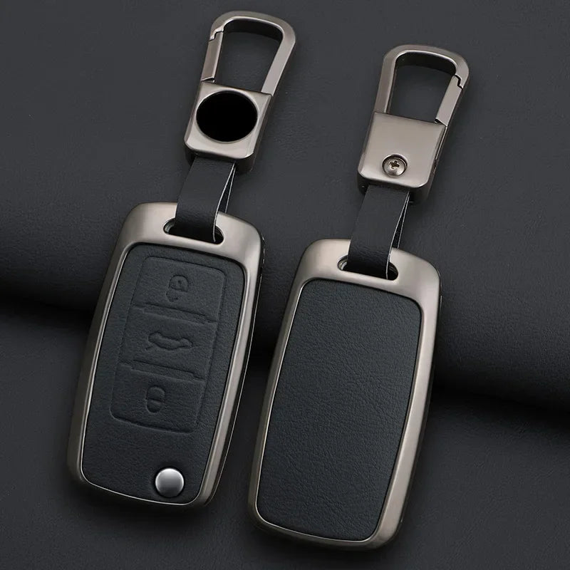 A pair of metallic key case covers with attached split rings and black rectangular key inserts.