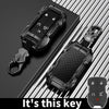 A black zinc alloy key fob case for a Chevy Silverado or GMC Sierra truck is shown with its attached key.
