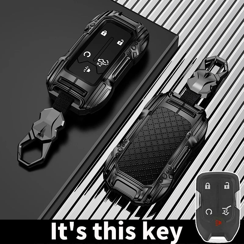 A black zinc alloy key fob case for a Chevy Silverado or GMC Sierra truck is shown with its attached key.