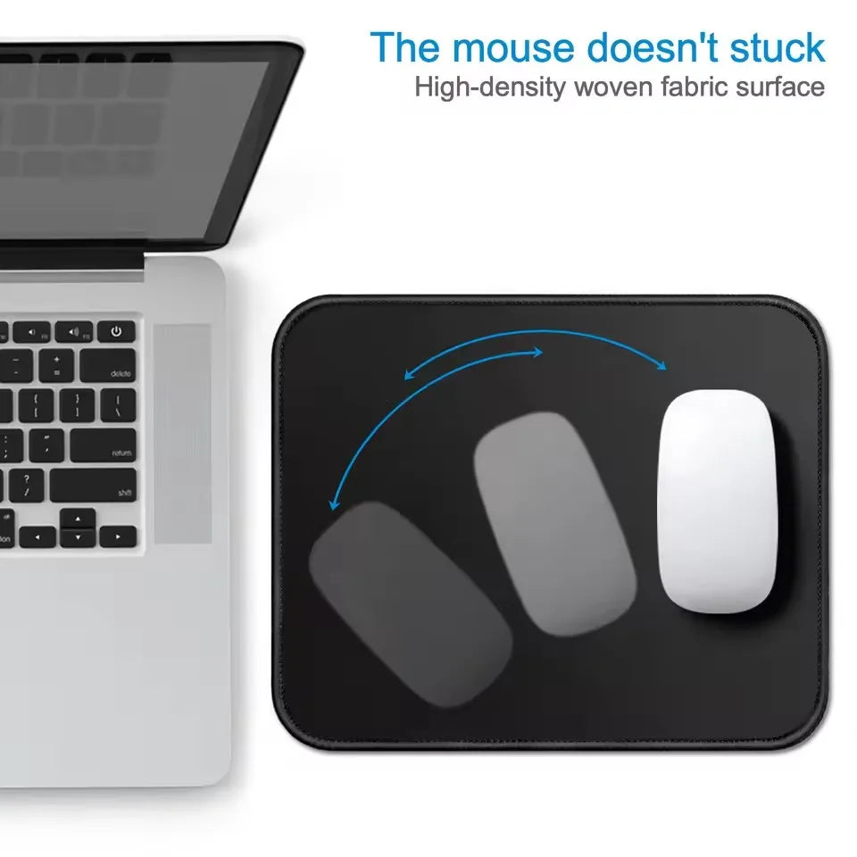 A black mouse pad with a stitched edge is shown next to a laptop, demonstrating its non-slip surface.