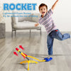 A young boy is launching a lightweight foam rocket toy set across a wooden floor.