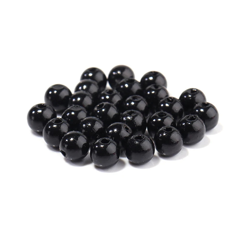 A pile of round black ABS imitation pearl beads for jewelry making