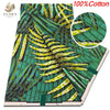 Green and yellow African wax print fabric featuring a dense pattern of leaves and branches