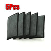 Five black microfiber scrubbing sponges stacked together.