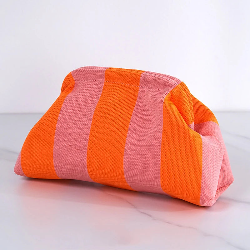 Pochette en crochet rayée orange et rose, posée sur une surface blanche.