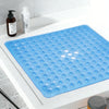 A blue non-slip shower mat with suction cups is displayed on a white surface next to soap bottles.