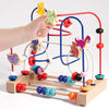 A hand is manipulating a wooden bead maze toy with colorful beads and maze paths.