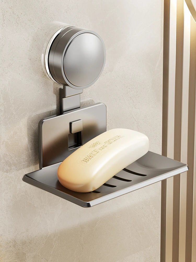 A silver wall-mounted soap dish with a suction cup dispenser is installed on a beige wall.