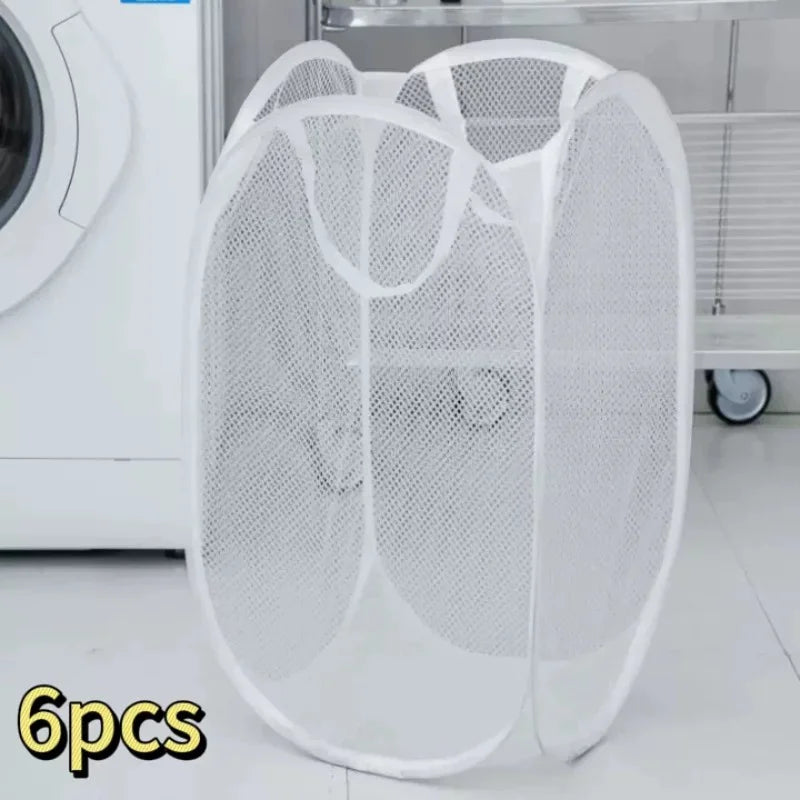 A white foldable mesh laundry basket with handles is shown next to a washing machine.
