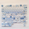 A collection of ocean blue PBT keycaps for mechanical keyboards arranged in a plastic tray.