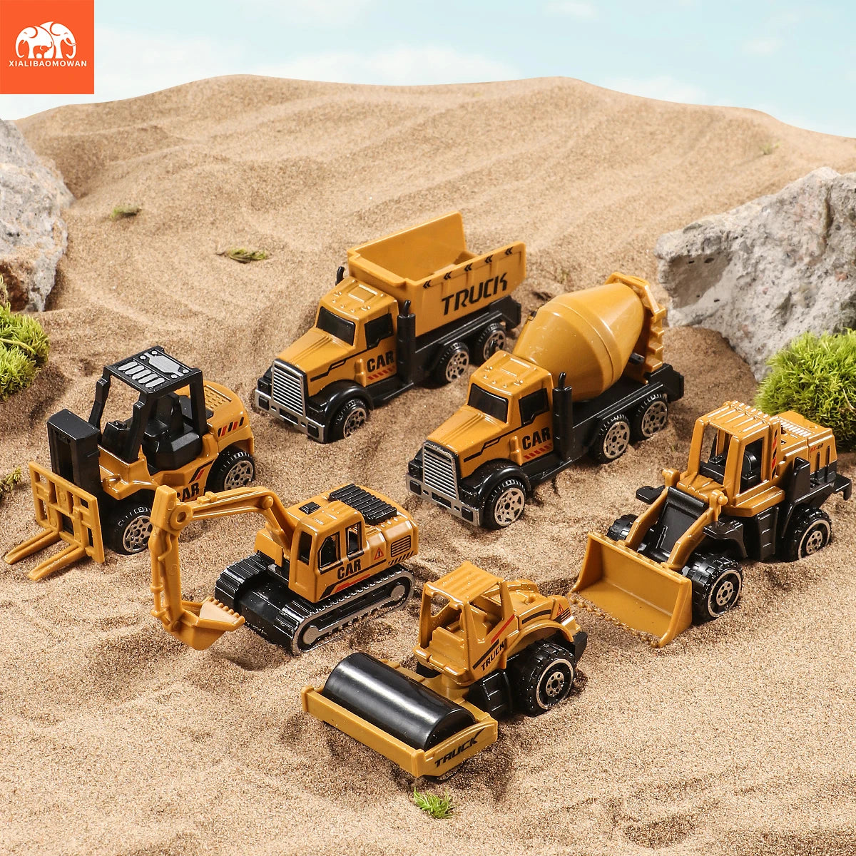 A set of diecast construction vehicles including a tractor, excavator, and truck toy models in yellow and black on sand.