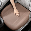 A hand rests on a tan breathable leather car seat cushion inside a vehicle interior.