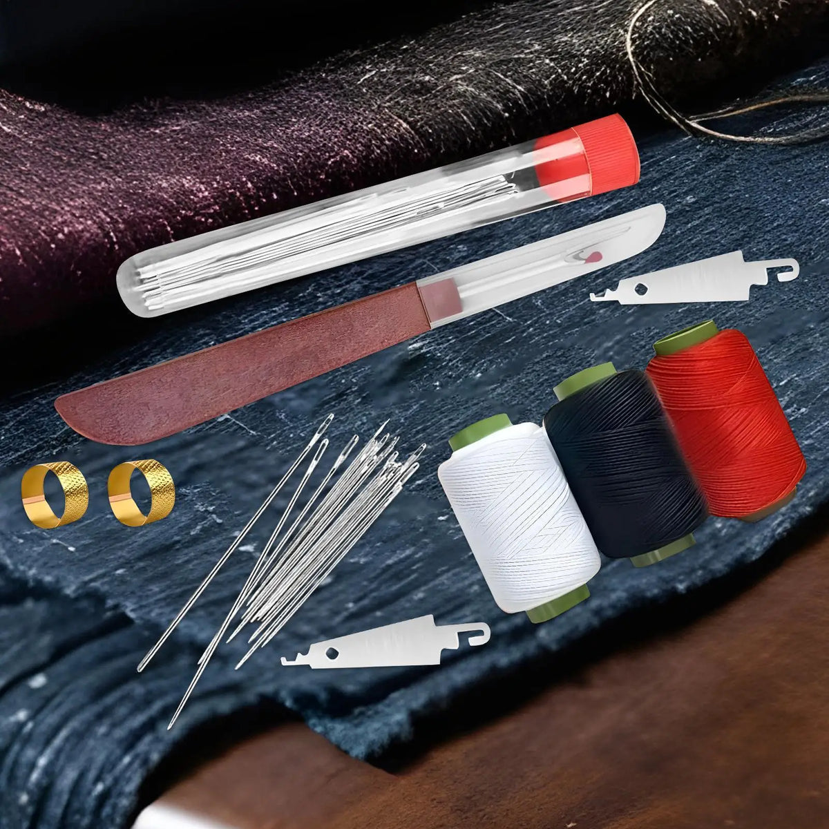 A portable bamboo sewing kit showing various needles, thread spools in red and black, and a small knife on dark fabric.