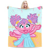 A pink and purple character illustration on a light blue background for a flannel throw blanket.