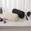 Two fabric storage bags, one beige quilted and one black, are displayed on a white surface.