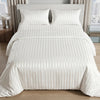 White satin striped jacquard duvet cover set on a bed with light curtains.