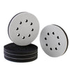 Two circular gray foam sanding pads and a stack of black sanding pads for random orbit sanders