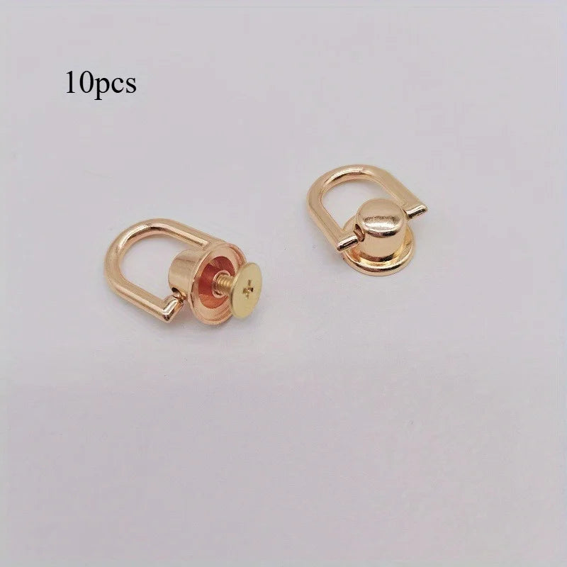 A set of ten gold-colored metal bag and phone case hardware components including clasps and screws.
